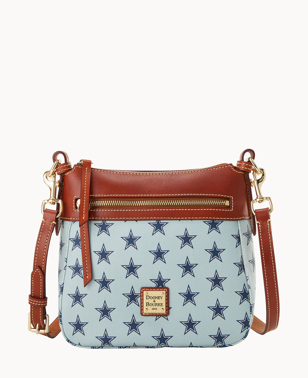 A shoulder bag with a light blue body featuring a dark blue star pattern, brown leather trim and strap, a gold zipper, and a Dooney & Bourke logo patch on the front.