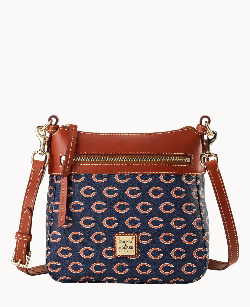A navy blue and brown leather crossbody bag with an all-over orange Chicago Bears C logo pattern, front zipper pocket, gold hardware, and a Dooney & Bourke label on the front.