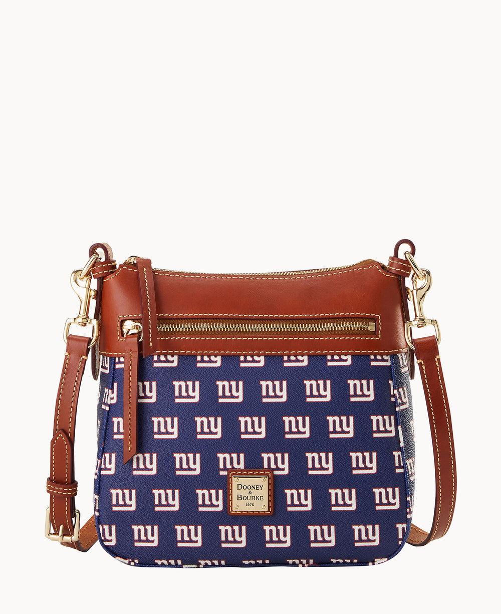 A blue and brown crossbody bag with tan leather trim, gold hardware, and a front zipper pocket, featuring a repeating white â€œnyâ€ logo pattern and a Dooney & Bourke label on the front.