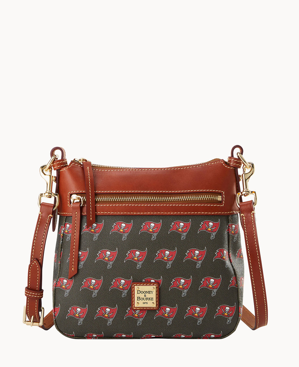 A crossbody bag with brown leather trim, gold hardware, and a printed pattern featuring the Tampa Bay Buccaneers logo. The front has a zipper pocket and a Dooney & Bourke logo patch.