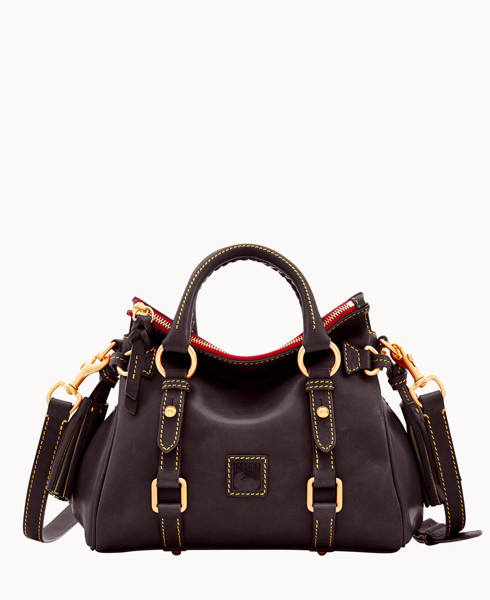 A dark leather handbag with gold hardware, double handles, a detachable shoulder strap, and visible yellow stitching. The bag has a red zipper and a rectangular patch on the front.