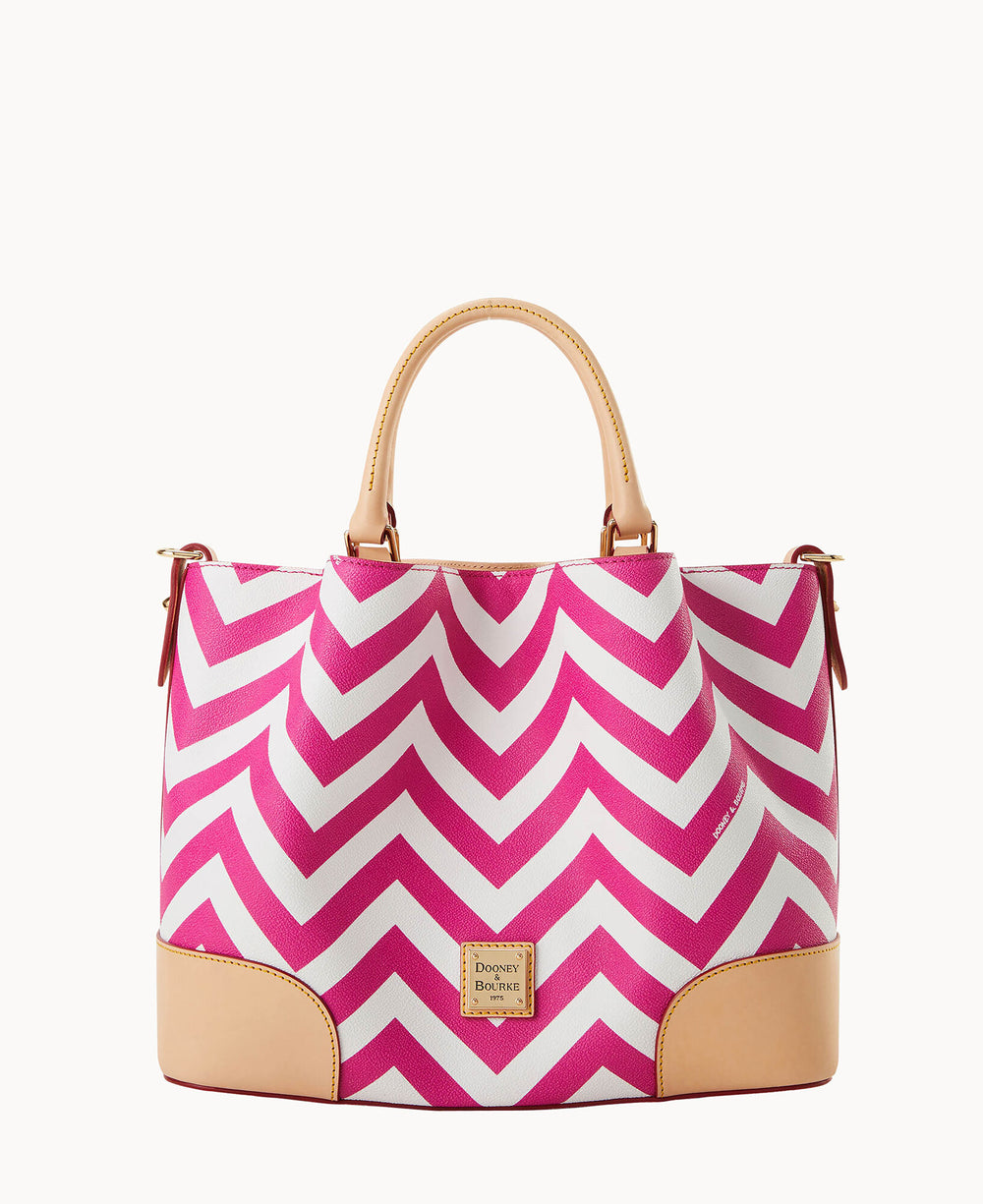 A stylish handbag with pink and white chevron stripes, tan leather handles, tan leather bottom corners, and a small Dooney & Bourke logo plate on the front.