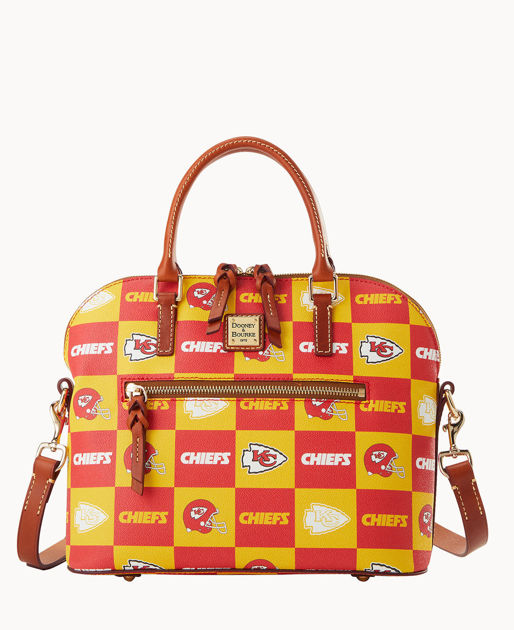 A red and yellow checkered handbag with â€œCHIEFSâ€ text and Kansas City Chiefs logos, brown leather handles, a front zipper, and a detachable shoulder strap. The brand â€œDooney & Bourkeâ€ is on a label above the zipper.