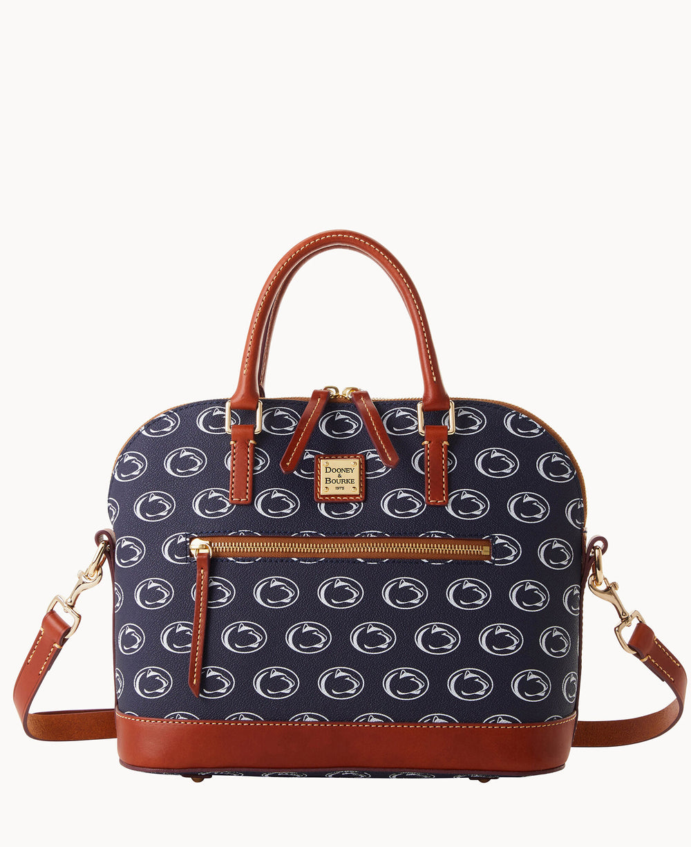 A navy blue handbag with brown leather handles and trim, featuring a repeating white Penn State Nittany Lions logo pattern, a front zip pocket, gold-tone hardware, and an adjustable shoulder strap.