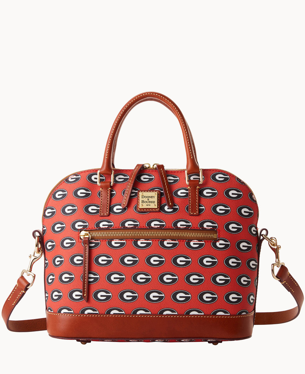 A red handbag with brown leather handles and trim, featuring a repeating black and white G pattern. The bag has gold hardware, a front zipper pocket, and a detachable shoulder strap.