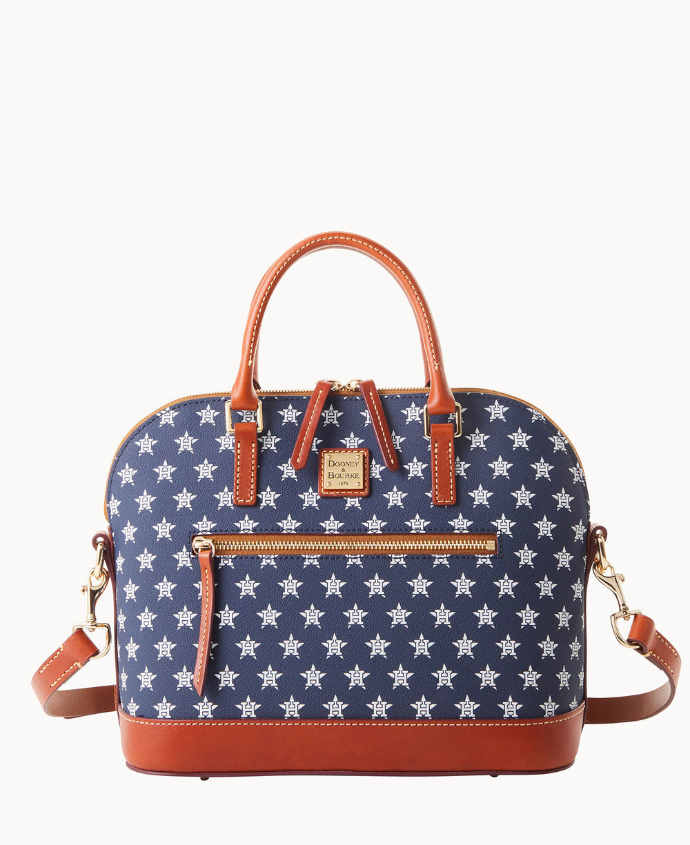 A blue handbag with white star patterns, brown leather handles, base, and trim, a front zip pocket, gold-tone hardware, and a detachable shoulder strap.
