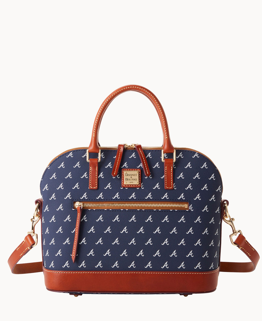 A navy blue handbag with brown leather handles and trim, featuring a repeating white A pattern, a front zip pocket, gold hardware, and detachable shoulder strap.