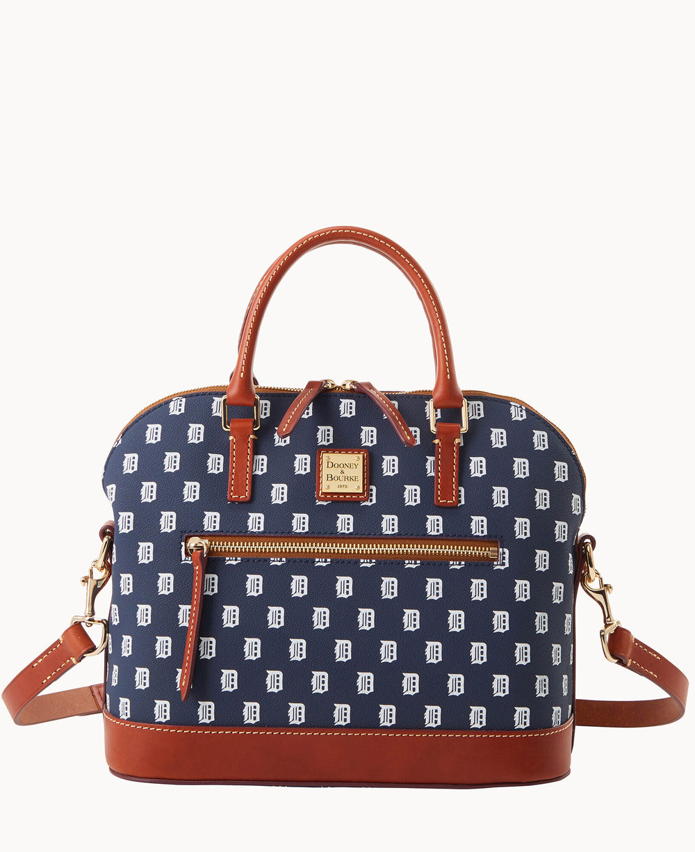A navy blue handbag with brown leather handles and trim, featuring a pattern of white D letters. The bag has a front zip pocket, gold-tone hardware, and a detachable shoulder strap.