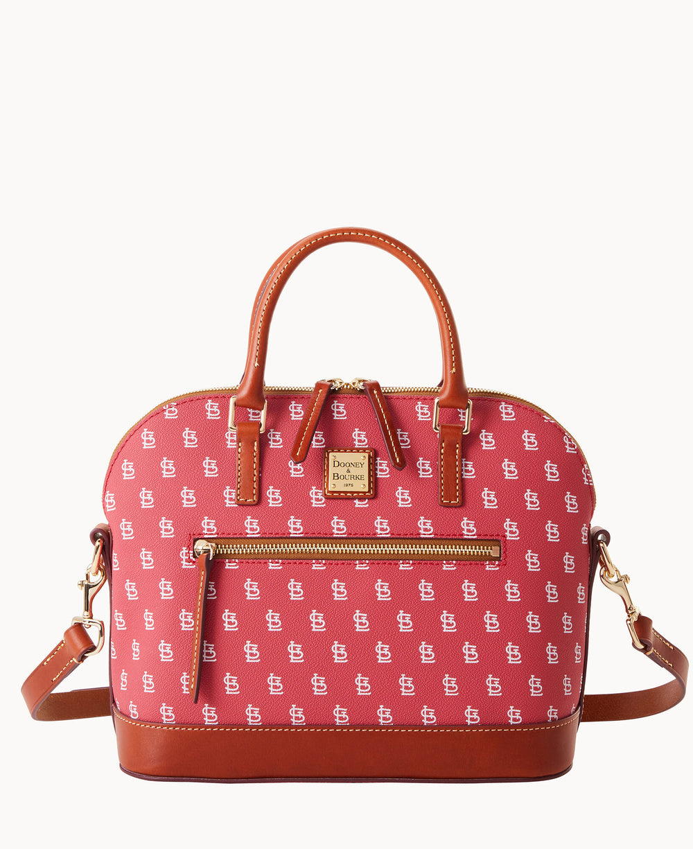 A red and brown handbag with a top handle, gold zippers, and a front pocket. The bag features a repeating white logo pattern and a detachable shoulder strap.