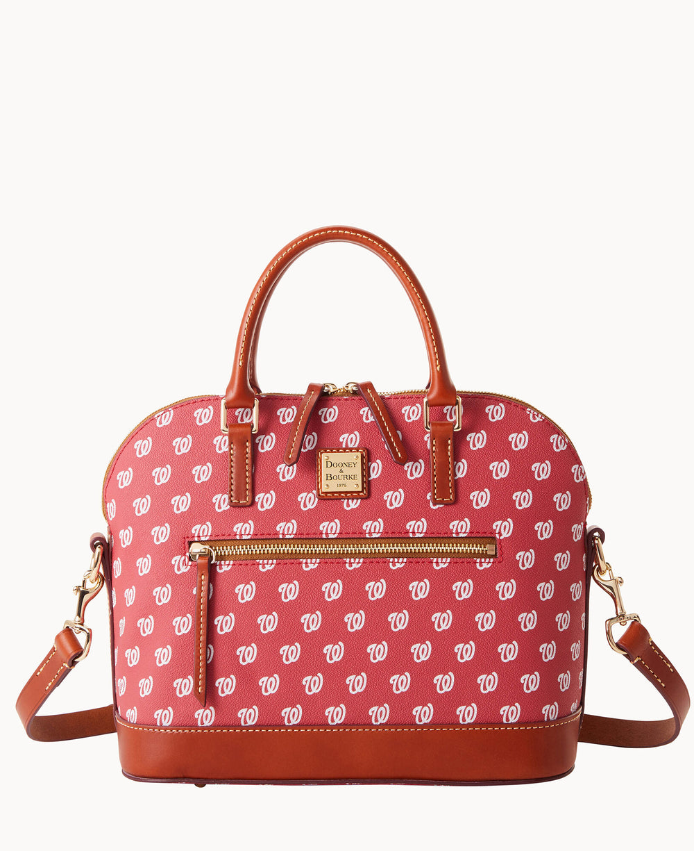 A red and brown handbag with tan leather handles and trim, featuring a repeating white W pattern and a front zip pocket. The bag has a detachable shoulder strap and a gold Dooney & Bourke logo plate.
