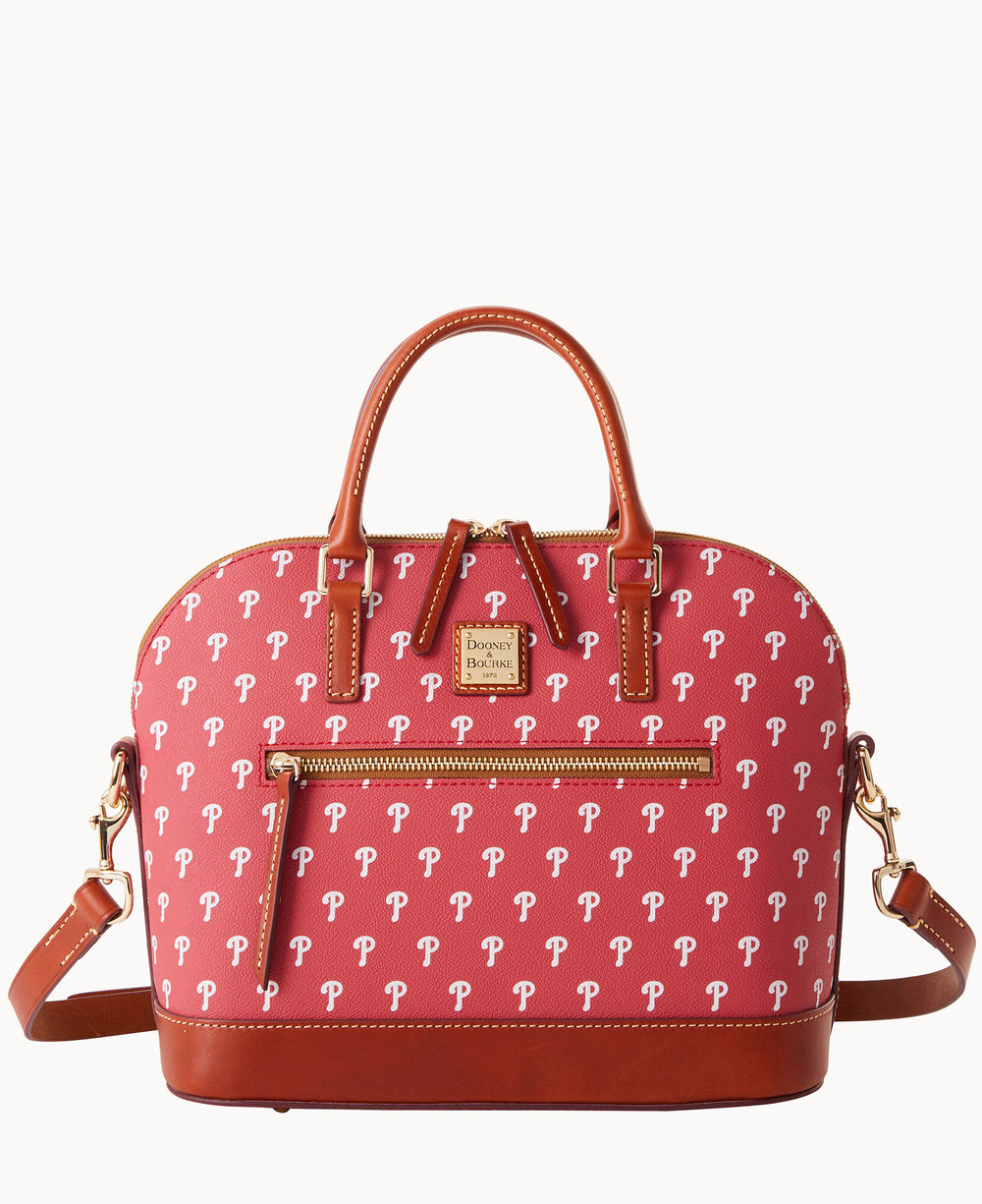 A red handbag with brown leather handles and trim, gold hardware, a front zipper pocket, and a repeating white letter P pattern. The bag has a removable shoulder strap and a small logo plate on the front.