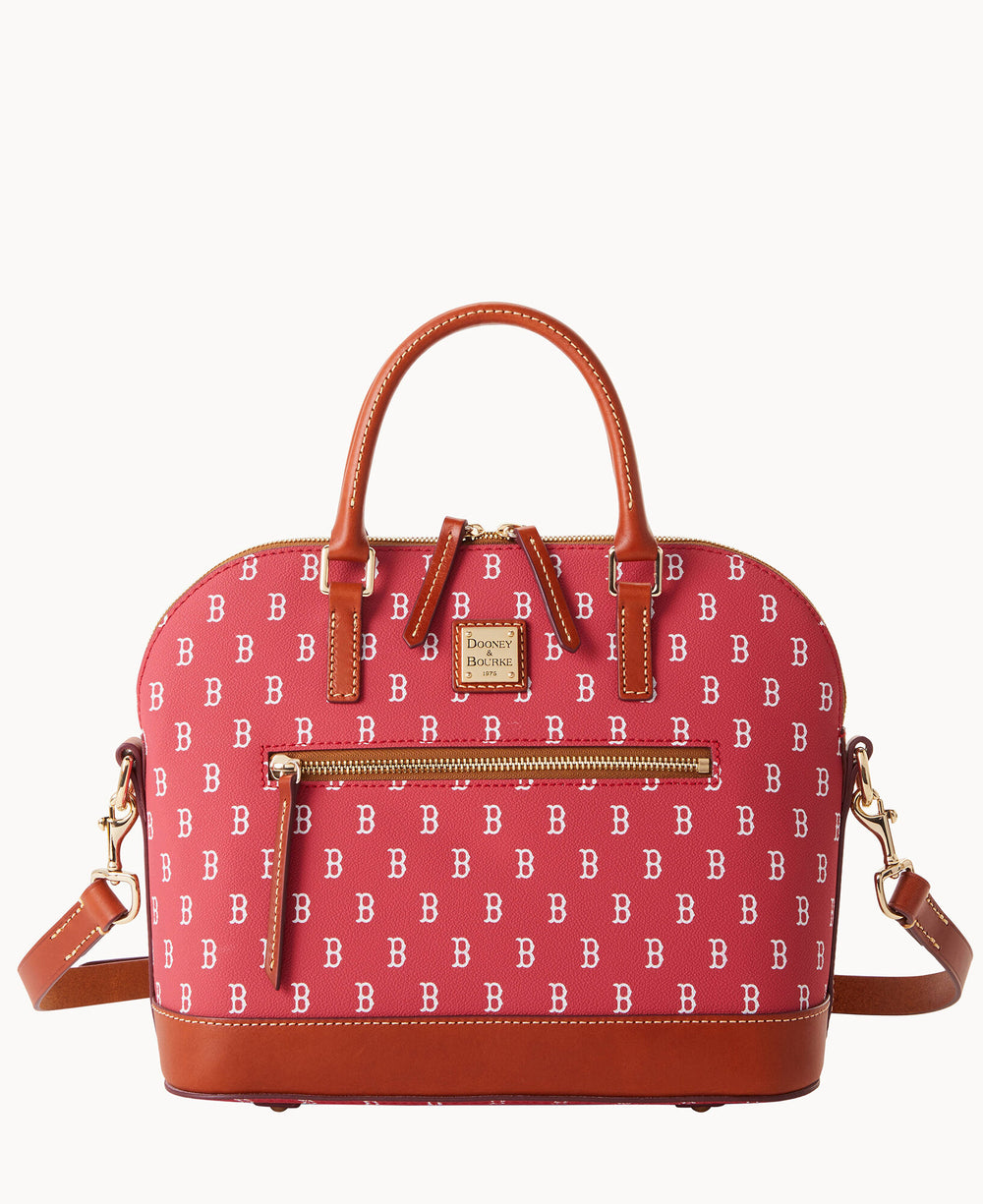 A red Dooney & Bourke handbag with brown leather handles and accents, gold hardware, a front zip pocket, and a repeating white B pattern across the fabric.