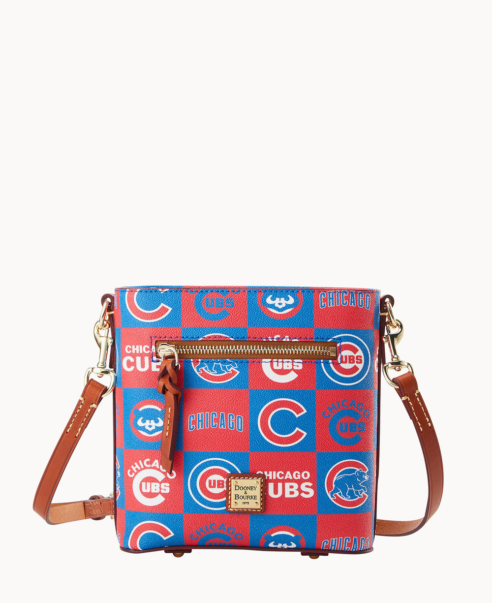A crossbody bag with brown leather straps featuring a red and blue checkerboard pattern with Chicago Cubs logos and text. The bag has a front zipper pocket and gold-tone hardware.