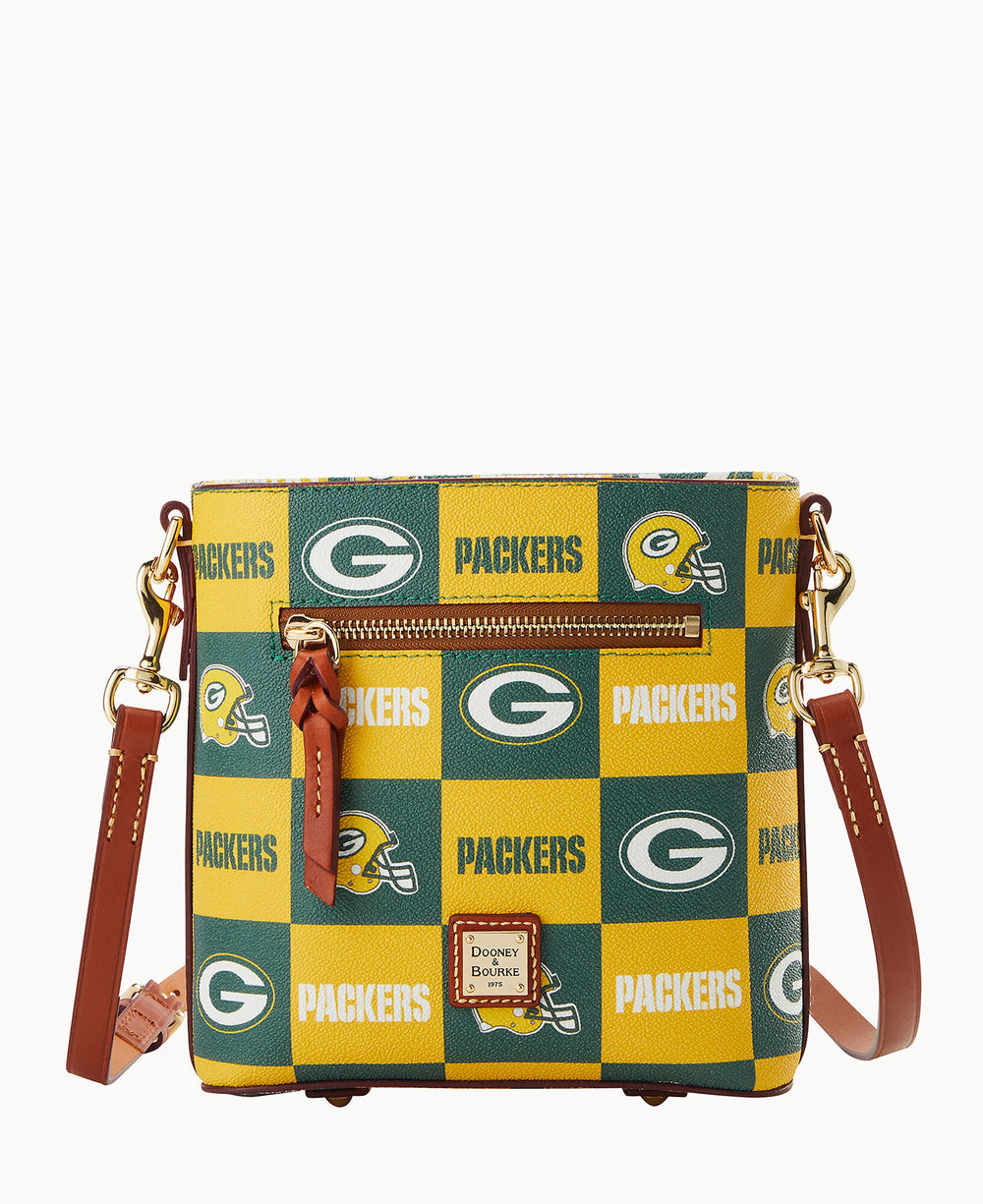 A square crossbody bag with a yellow and green checkerboard pattern featuring the Green Bay Packers logo, team name, and a football helmet; it has a front zipper pocket and brown leather strap.