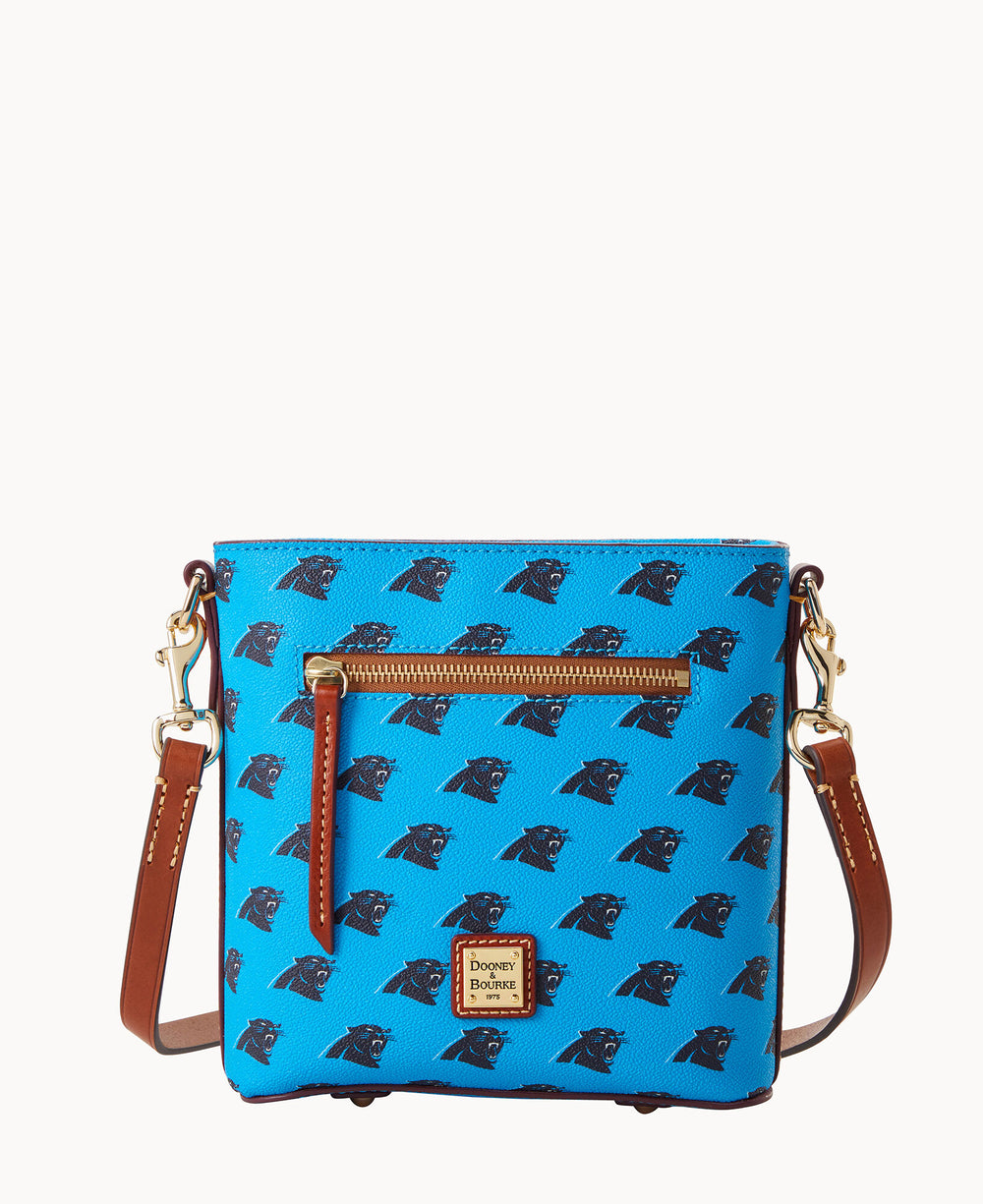 A bright blue crossbody bag with brown leather straps, featuring a repeating black panther head logo pattern, a front zip pocket, and a small gold Dooney & Bourke label at the bottom center.
