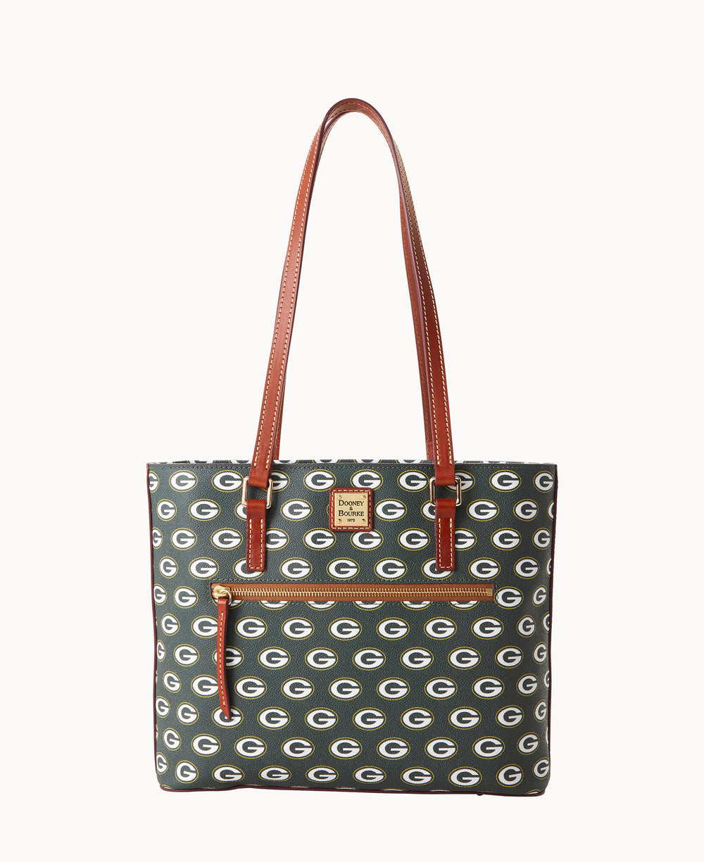 A tote bag with brown leather straps and trim, featuring a repeating pattern of Green Bay Packers logos on a dark background, and a front zippered pocket.