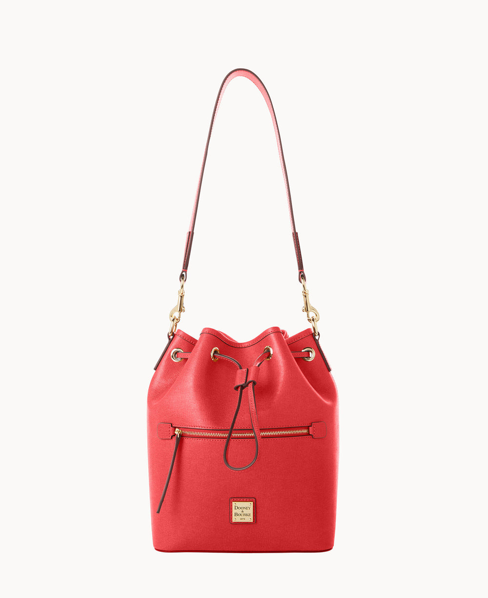 A red leather bucket bag with a top handle, gold hardware, front zip pocket, drawstring closure, and a small branded logo plate near the base.