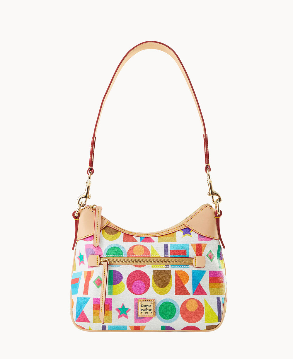 A stylish handbag with a tan strap, gold hardware, and a colorful geometric pattern featuring circles, squares, stars, and triangles in red, blue, green, yellow, and pink.