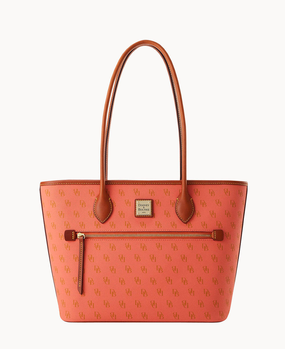 A coral pink tote bag with brown leather handles and trim, featuring a subtle monogram pattern, a front zip pocket, and a small gold Dooney & Bourke logo plate.