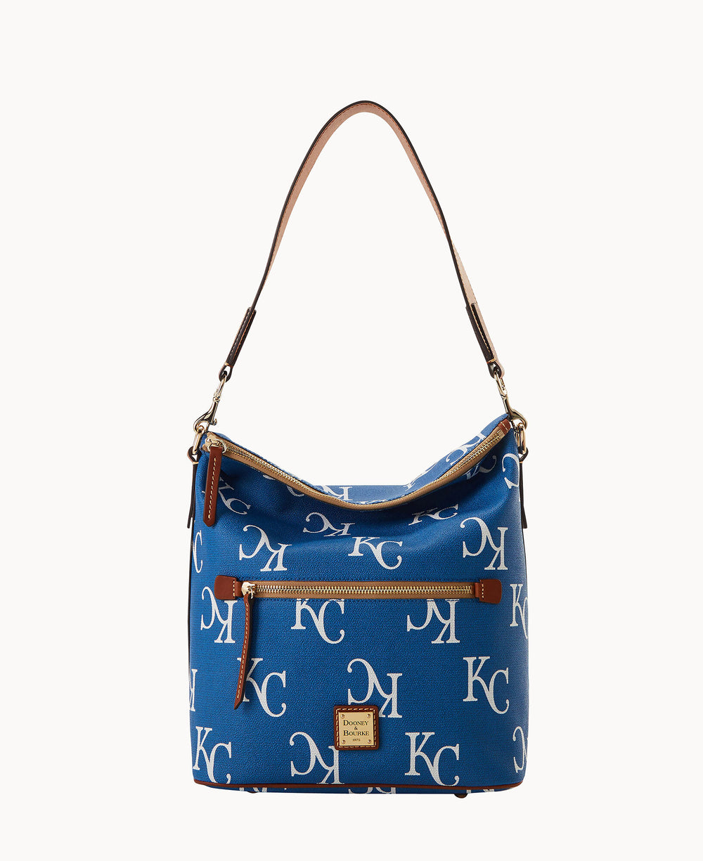 Blue Dooney & Bourke shoulder bag with an all-over white KC logo pattern, front zip pocket, brown leather strap, and a small leather logo patch near the bottom.