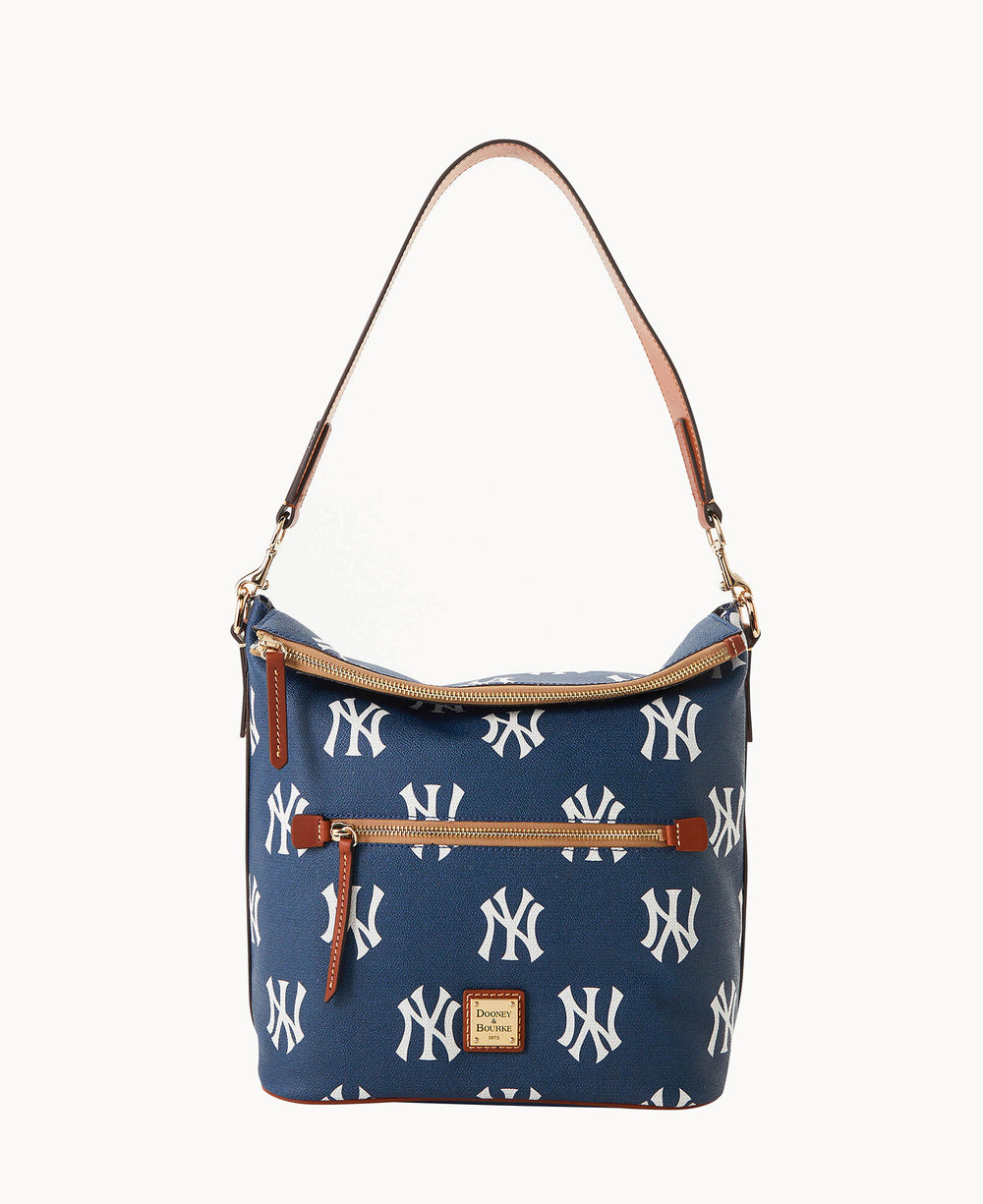 A blue shoulder bag with tan leather accents, featuring a repeating white New York Yankees logo pattern and gold zippers, designed by Dooney & Bourke.