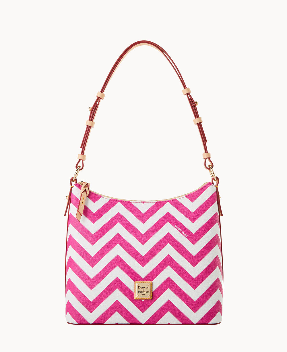 A handbag with a pink and white chevron pattern, featuring a brown adjustable shoulder strap and a gold brand logo plaque on the front.