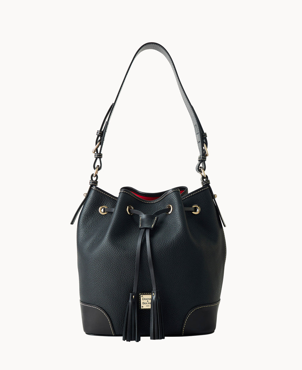 A black leather bucket bag with a single shoulder strap, gold hardware, drawstring closure, tassel accents, contrast stitching, and a small gold logo plate on the front.