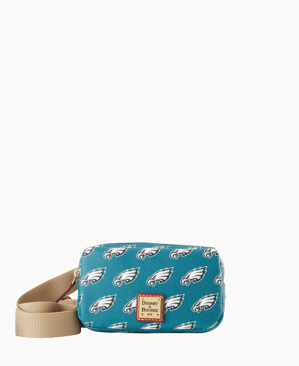 A small teal crossbody bag with tan strap, decorated with repeating Philadelphia Eagles logos and a brown Dooney & Bourke label on the front.