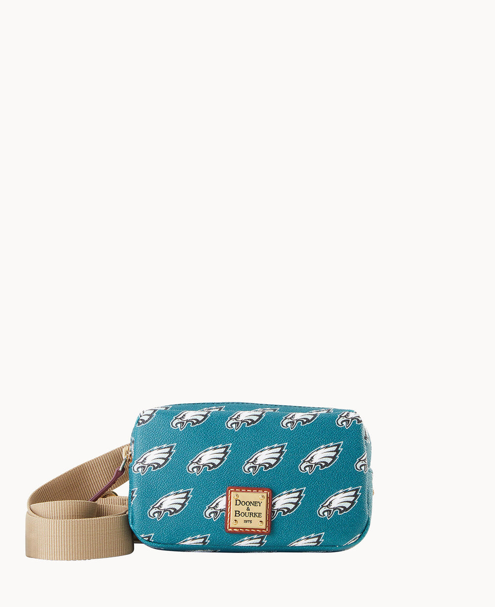 A small teal crossbody bag with tan strap, decorated with repeating Philadelphia Eagles logos and a brown Dooney & Bourke label on the front.