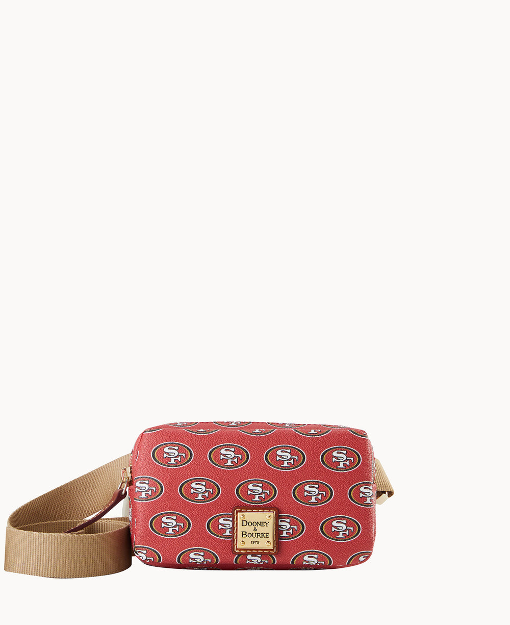 A red crossbody bag with a tan strap, featuring a repeating San Francisco 49ers logo pattern and a Dooney & Bourke label on the front.