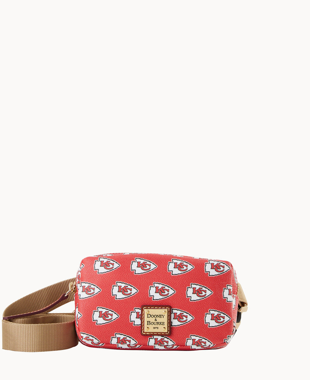 A red Dooney & Bourke crossbody bag featuring a repeating Kansas City Chiefs logo pattern and a tan adjustable strap.