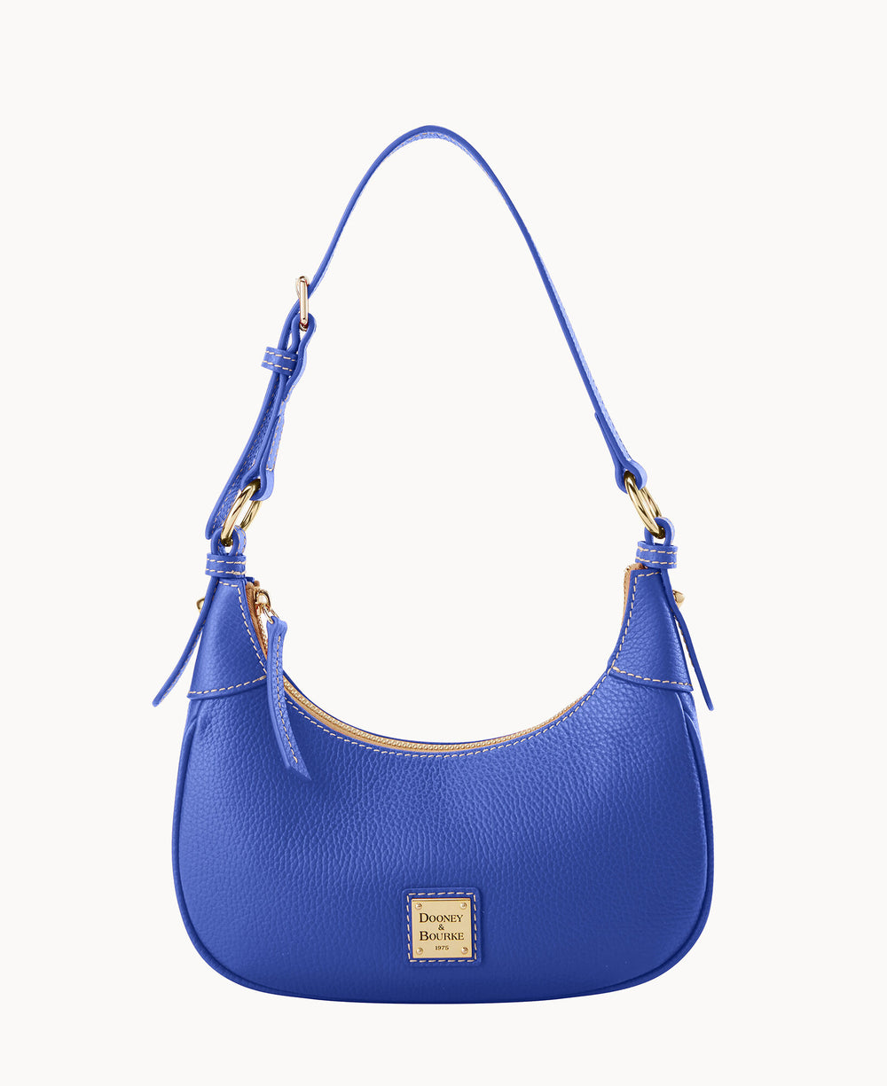 A small blue leather shoulder bag with gold hardware, an adjustable strap, and a Dooney & Bourke logo plate on the front. The bag has a simple, curved design and a zippered top closure.