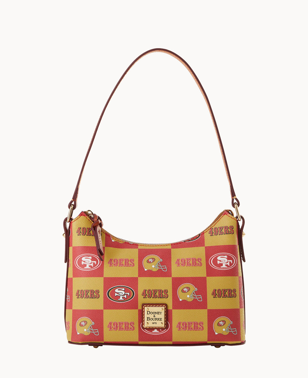 A shoulder bag with a red and yellow San Francisco 49ers checkerboard pattern, featuring the team logo and 49ERS text, brown leather strap, and a Dooney & Bourke label on the front.