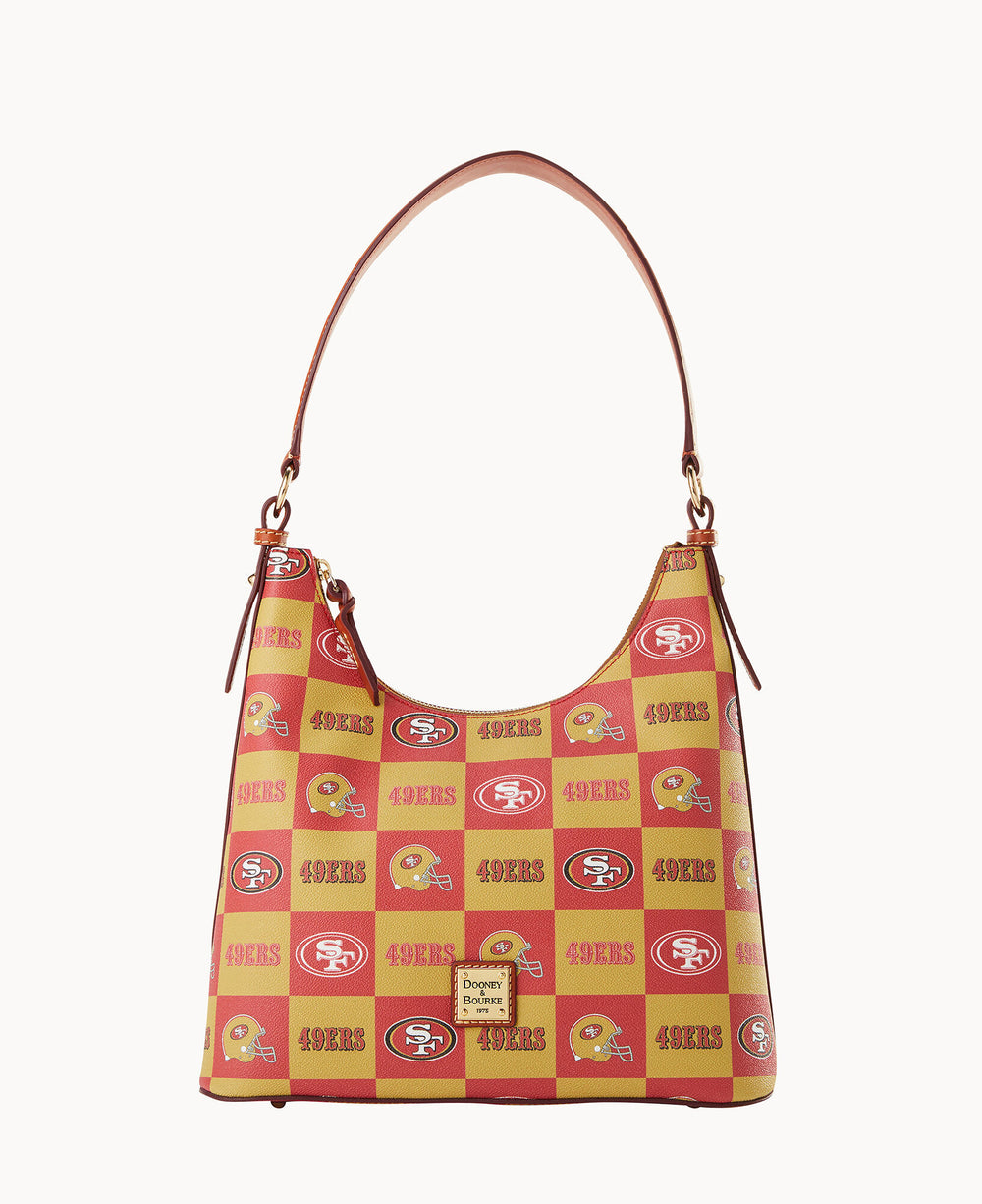 A handbag with a red and yellow checkered pattern featuring the San Francisco 49ers logos, helmets, and 49ERS text, and a brown leather strap and trim.