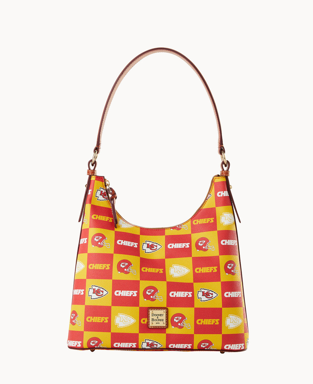 A handbag with a brown strap featuring a red and yellow checkerboard pattern and Kansas City Chiefs logos, along with the word CHIEFS and a Dooney & Bourke label on the front.