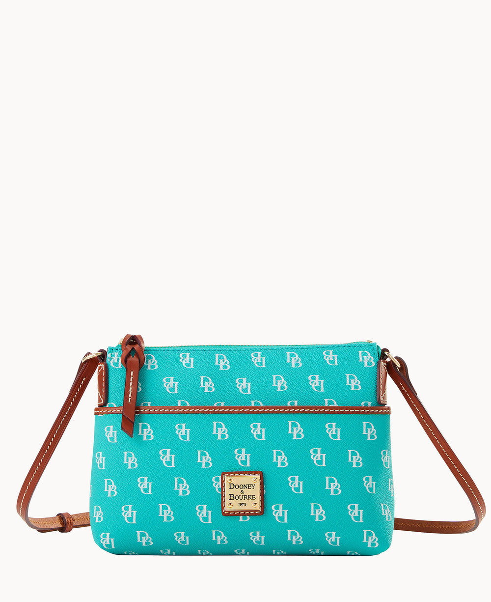 A turquoise crossbody bag with brown leather strap and trim, decorated with a white DB pattern and a gold Dooney & Bourke logo plate on the front.