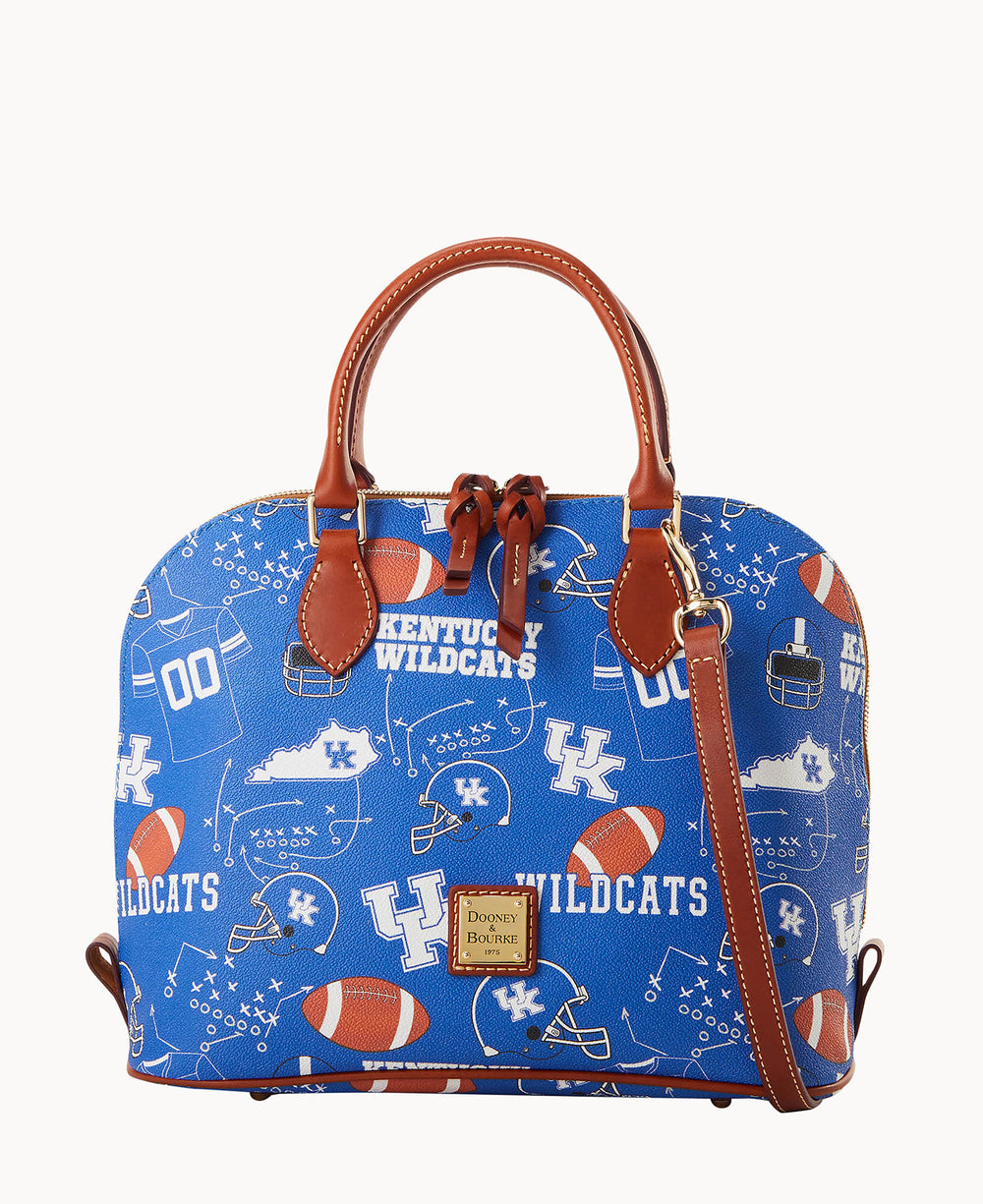 A blue Dooney & Bourke handbag with brown leather handles and trim, featuring University of Kentucky Wildcats logos, footballs, helmets, and related graphics in white and orange.