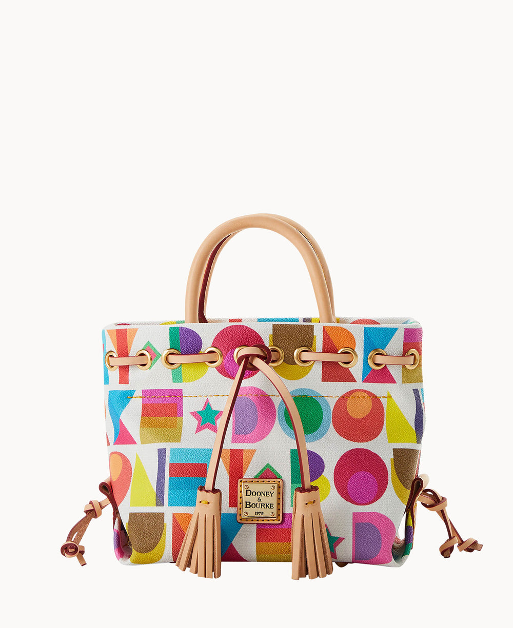 A colorful handbag with a geometric pattern, tan leather handles, tan drawstring and tassels, and a small Dooney & Bourke logo patch on the front. The background is white.