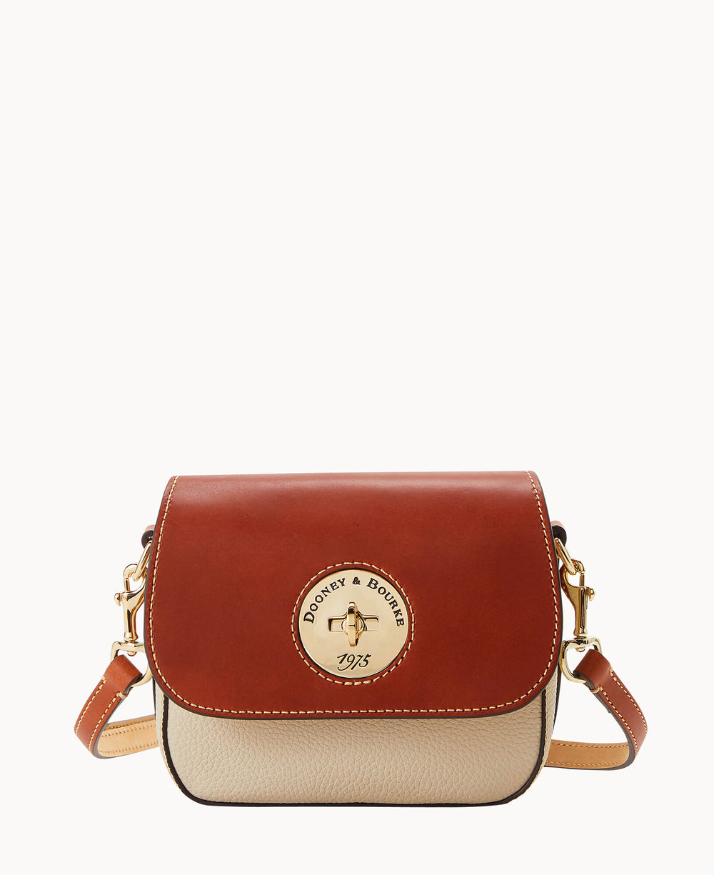 A small crossbody bag with a brown leather flap, beige body, gold hardware, and an embossed circular Dooney & Bourke 1975 logo on the front. The bag has an adjustable leather strap.