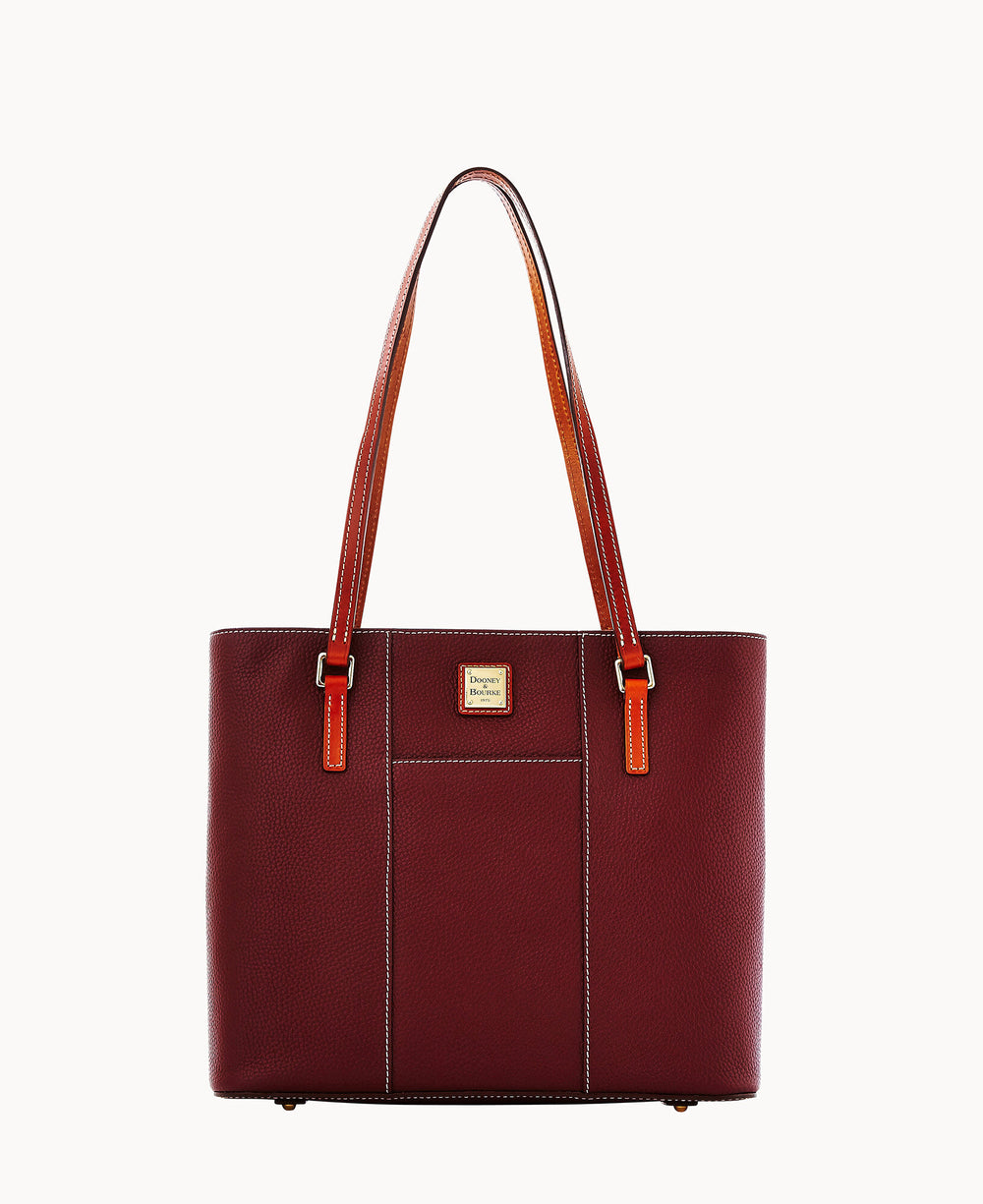 A burgundy leather tote bag with two brown shoulder straps, gold-tone hardware, and a small gold logo plate on the front. The bag has a front slip pocket and a structured, rectangular shape.