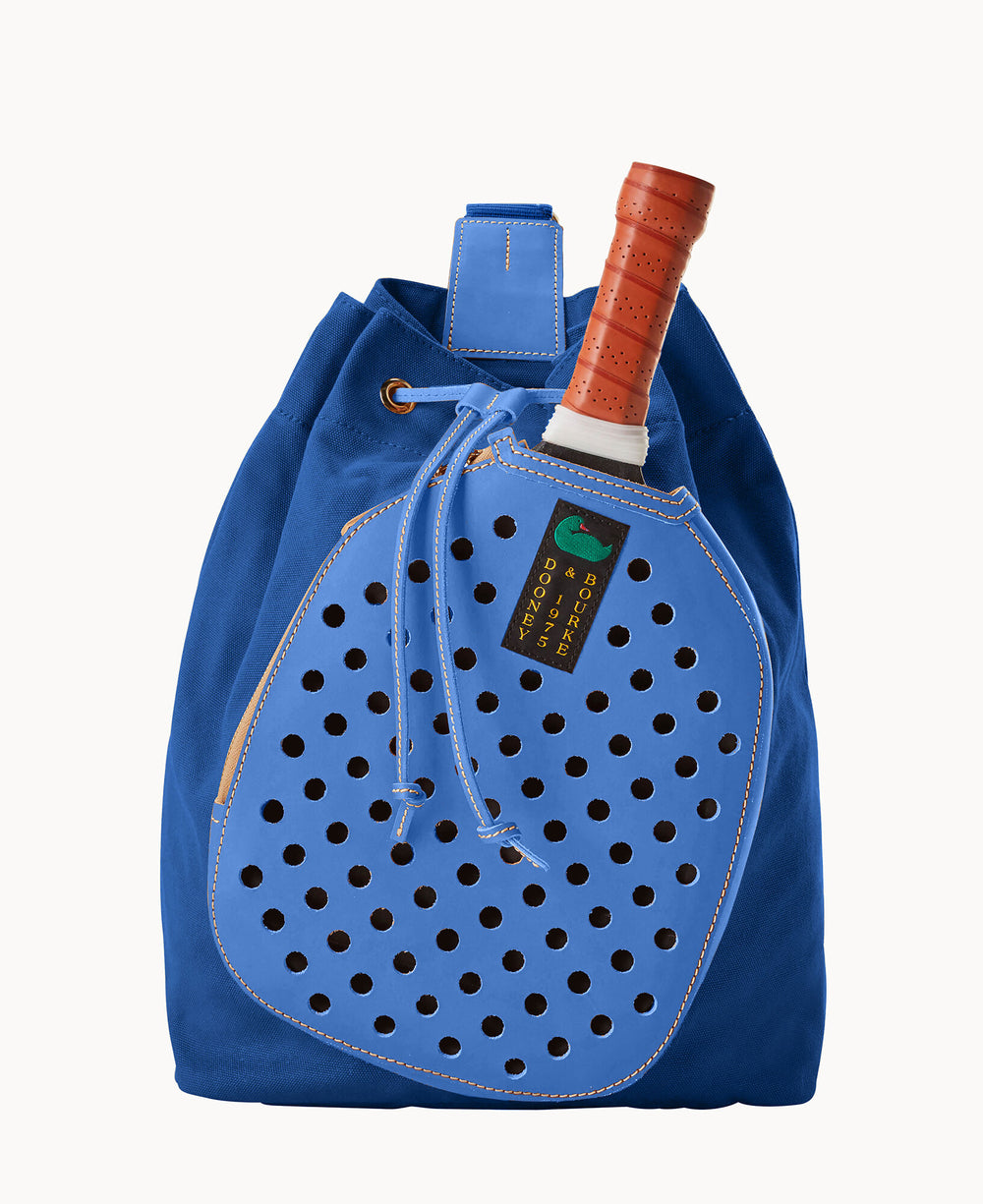 A royal blue drawstring bag with a circular perforated front pocket, shaped like a tennis racket, holding a tennis racket with an orange grip partially visible.