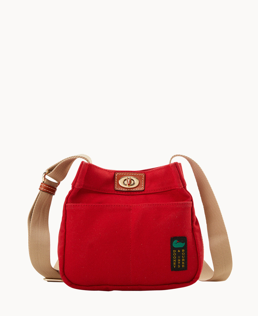A small red shoulder bag with a tan adjustable strap, a front pocket, a gold turn-lock closure, and a green and yellow tag on the side, displayed against a plain white background.