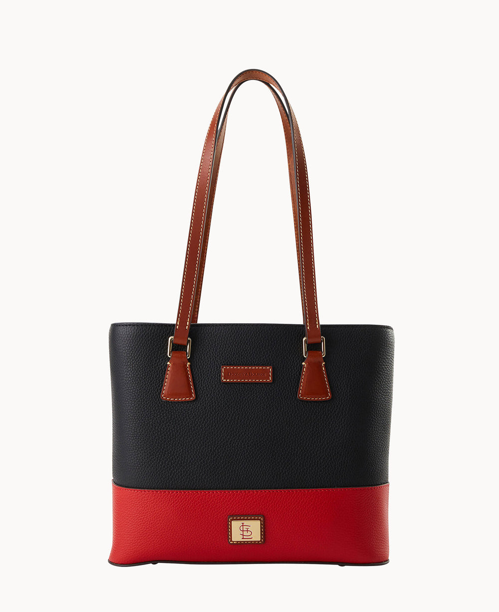 A stylish tote bag with long brown handles, a black upper section, a red lower section, and a small logo patch on the front.