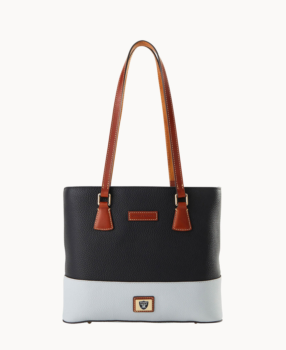 A two-tone leather tote bag with long brown handles, a black upper section, a light gray lower section, and a small rectangular logo patch on the front bottom center.
