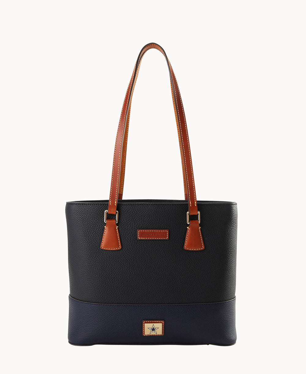 A black textured leather tote bag with two long brown handles and gold-tone hardware. The front features a small rectangular patch with a star logo at the bottom center. The background is plain white.