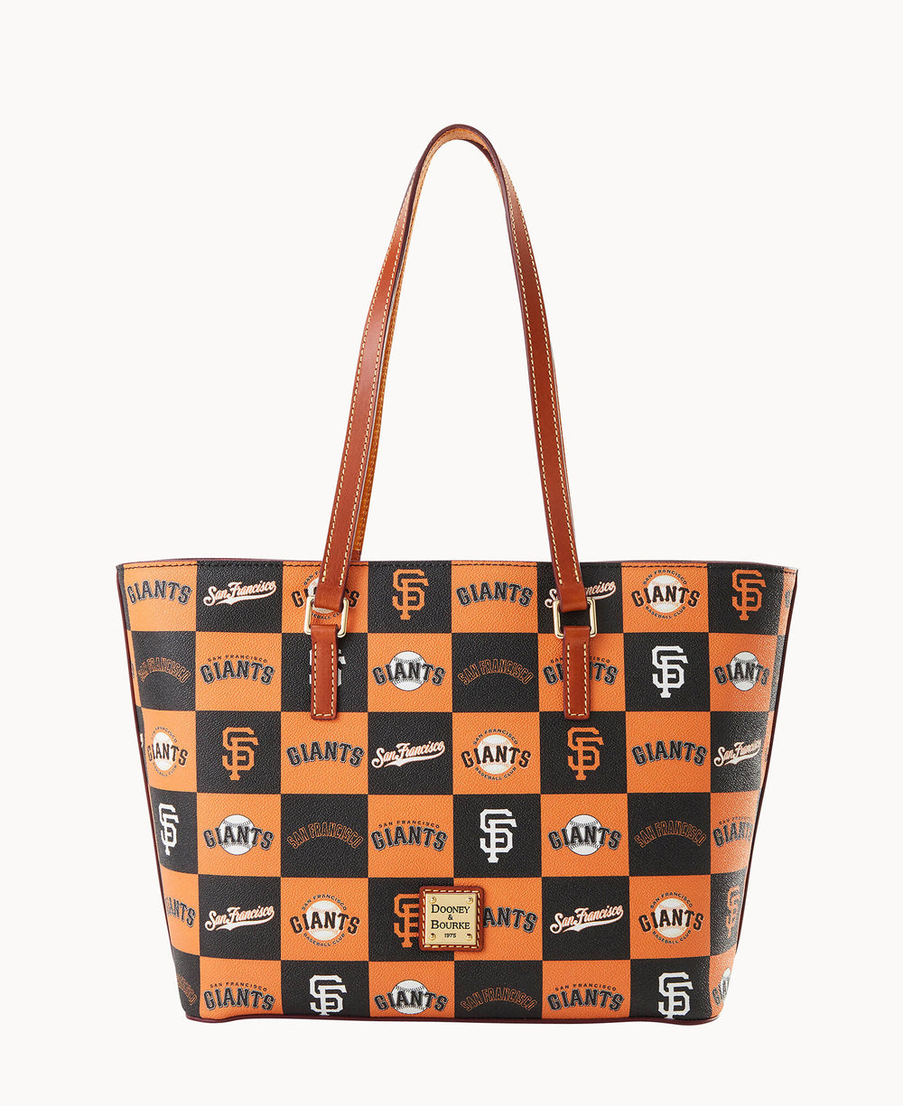 A tote bag with brown handles, featuring a checkered pattern of orange and black squares, each printed with various San Francisco Giants logos and the Dooney & Bourke brand label on the front.