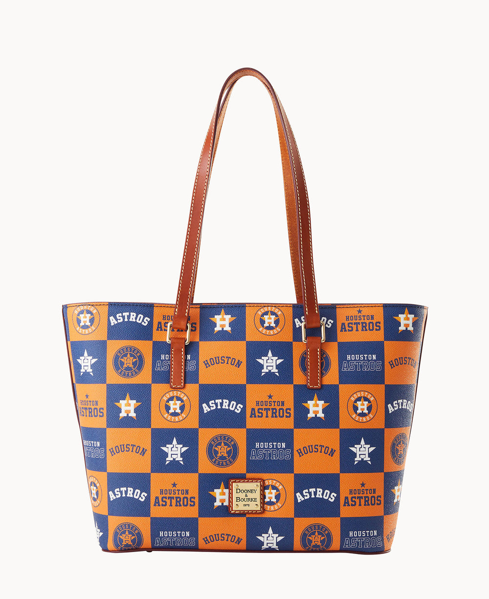 A tote bag with brown leather handles, featuring a blue and orange checkerboard pattern with Houston Astros logos and text, designed by Dooney & Bourke.