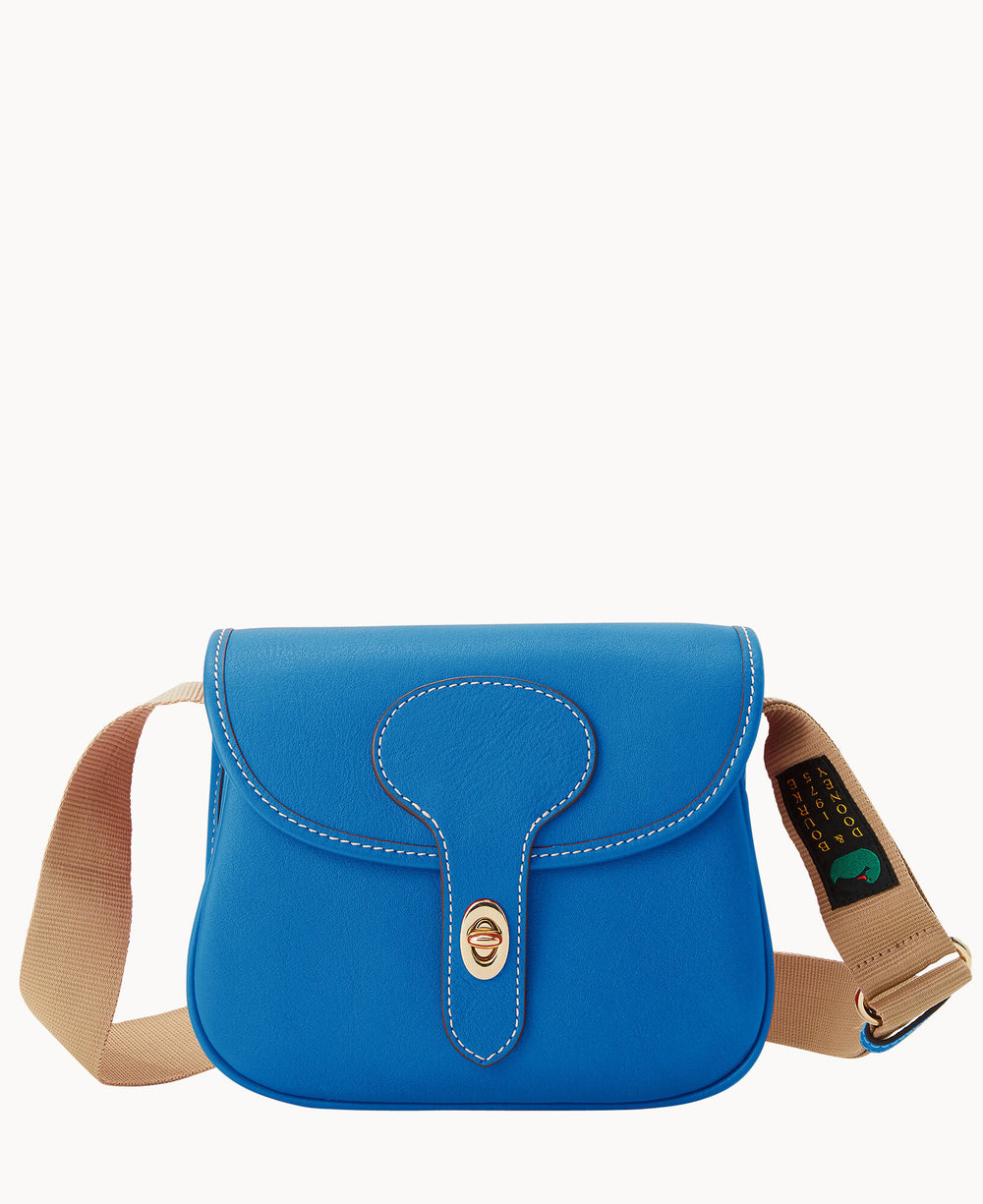A small, bright blue leather crossbody bag with white stitching, a curved flap, gold-tone clasp, and an adjustable beige canvas strap featuring a green and black label. The background is plain white.