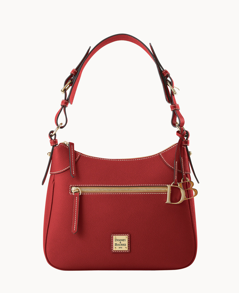 A red leather Dooney & Bourke handbag with gold hardware, a front zipper pocket, adjustable shoulder strap, and a gold logo plate on the front. The bag features decorative buckle details on the sides.