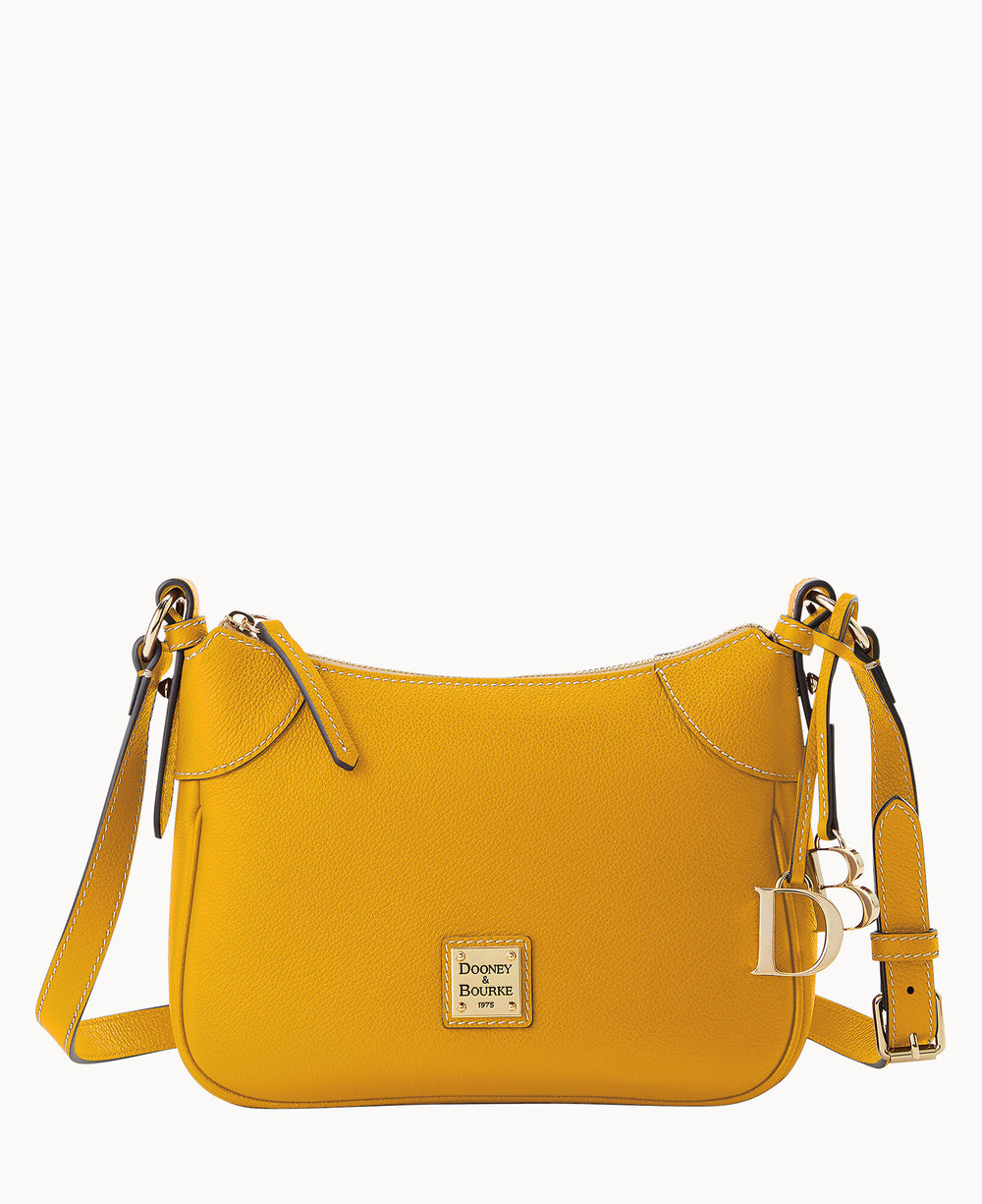 A yellow leather crossbody bag with gold hardware, a matching adjustable strap, a front zipper, and a small Dooney & Bourke logo plaque on the front. The strap has a â€œDBâ€ charm attached.